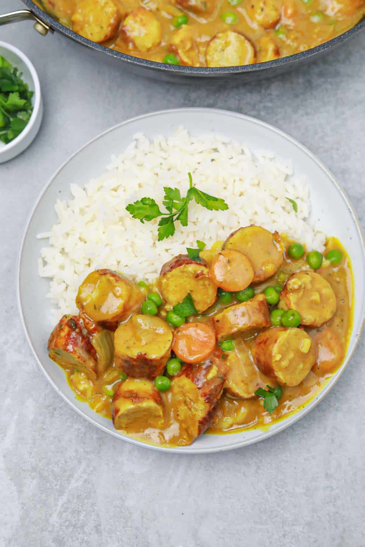 curried sausages served on rice in a bowl.