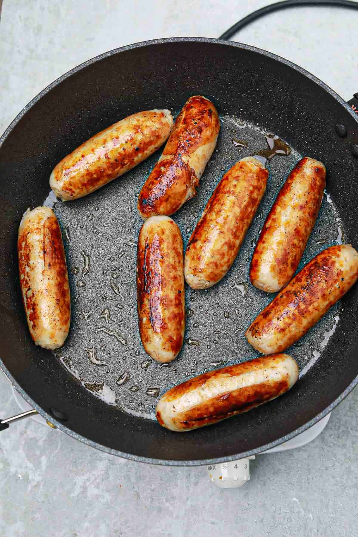 cooked sausages in a pan.