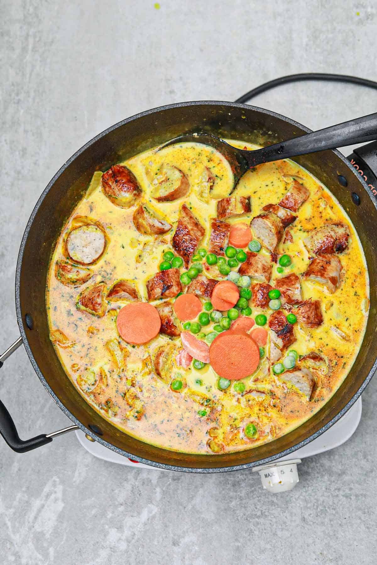 sausage, carrots and peas added to the skillet.