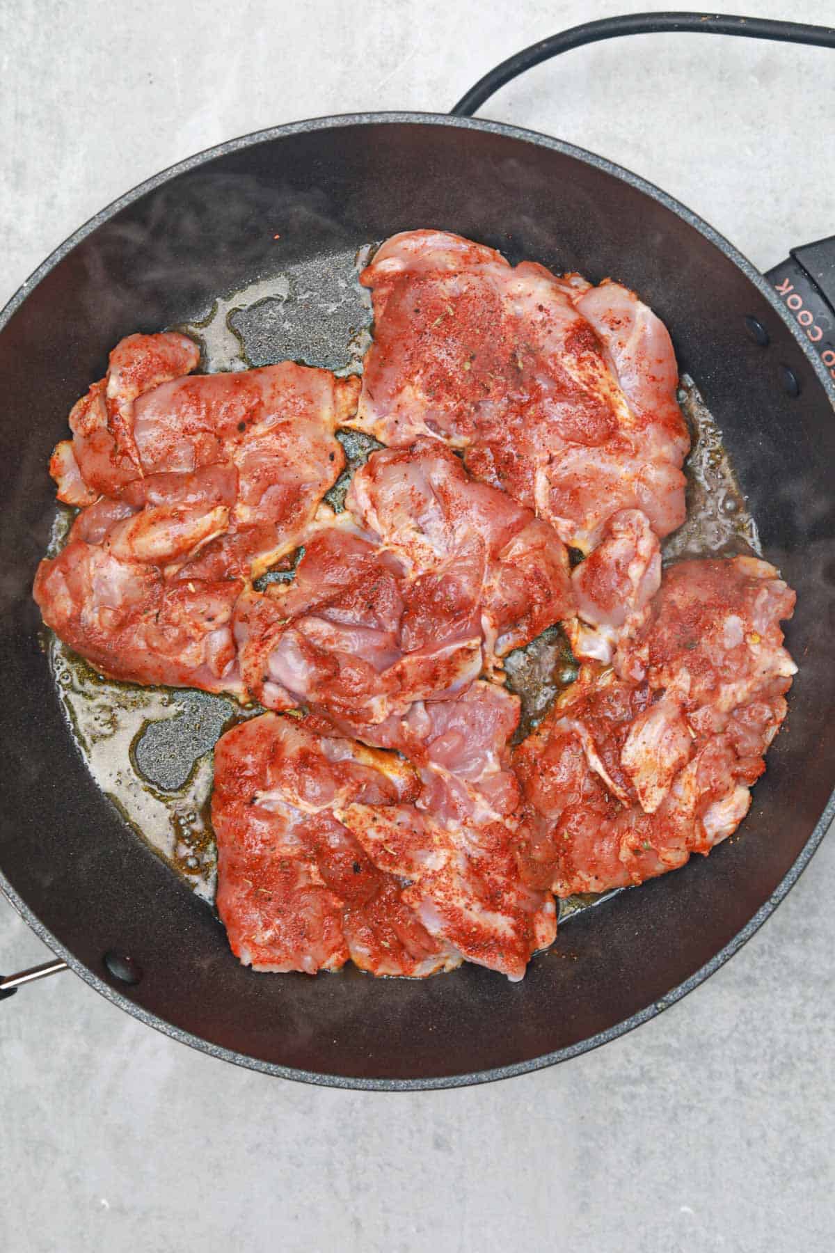 the chicken thighs in the frying pan.