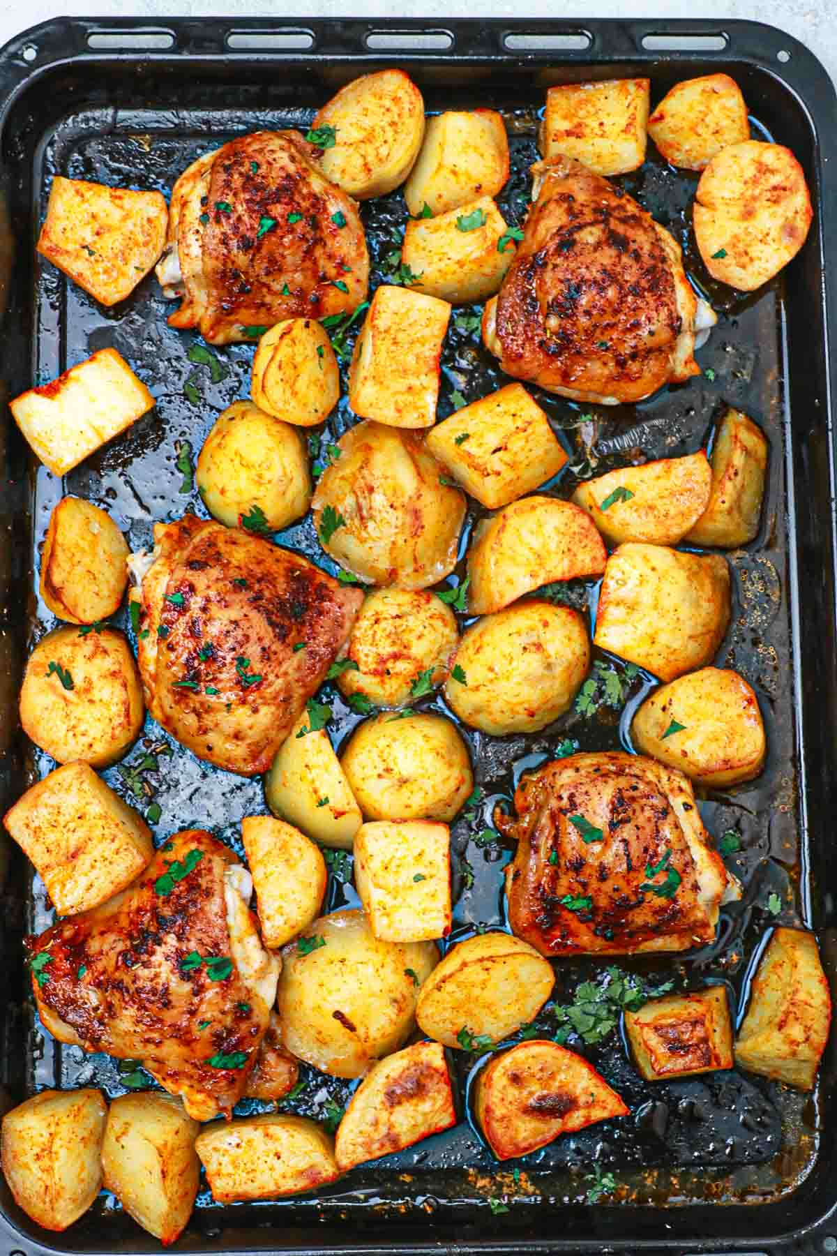 baked chicken thighs and potatoes in a sheet pan.