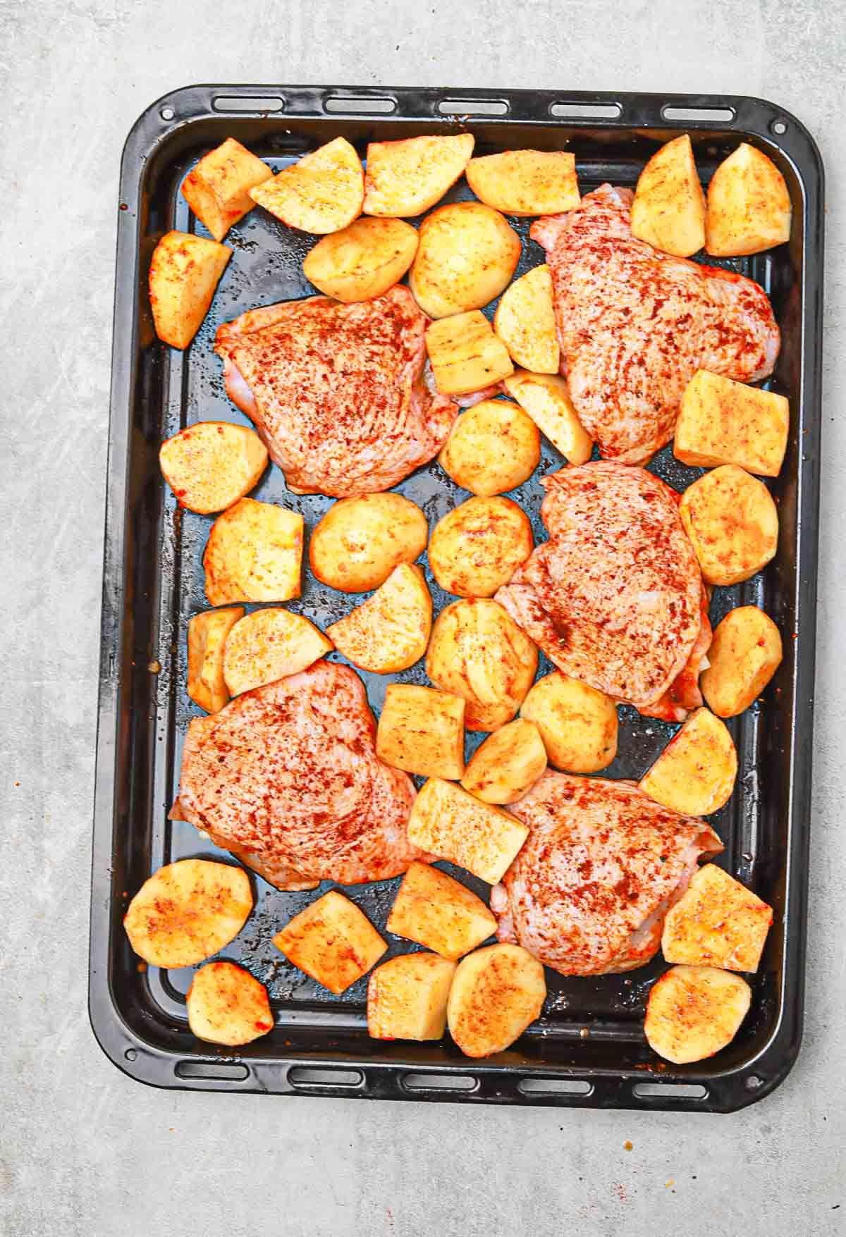 chicken and potatoes in a baking tray.