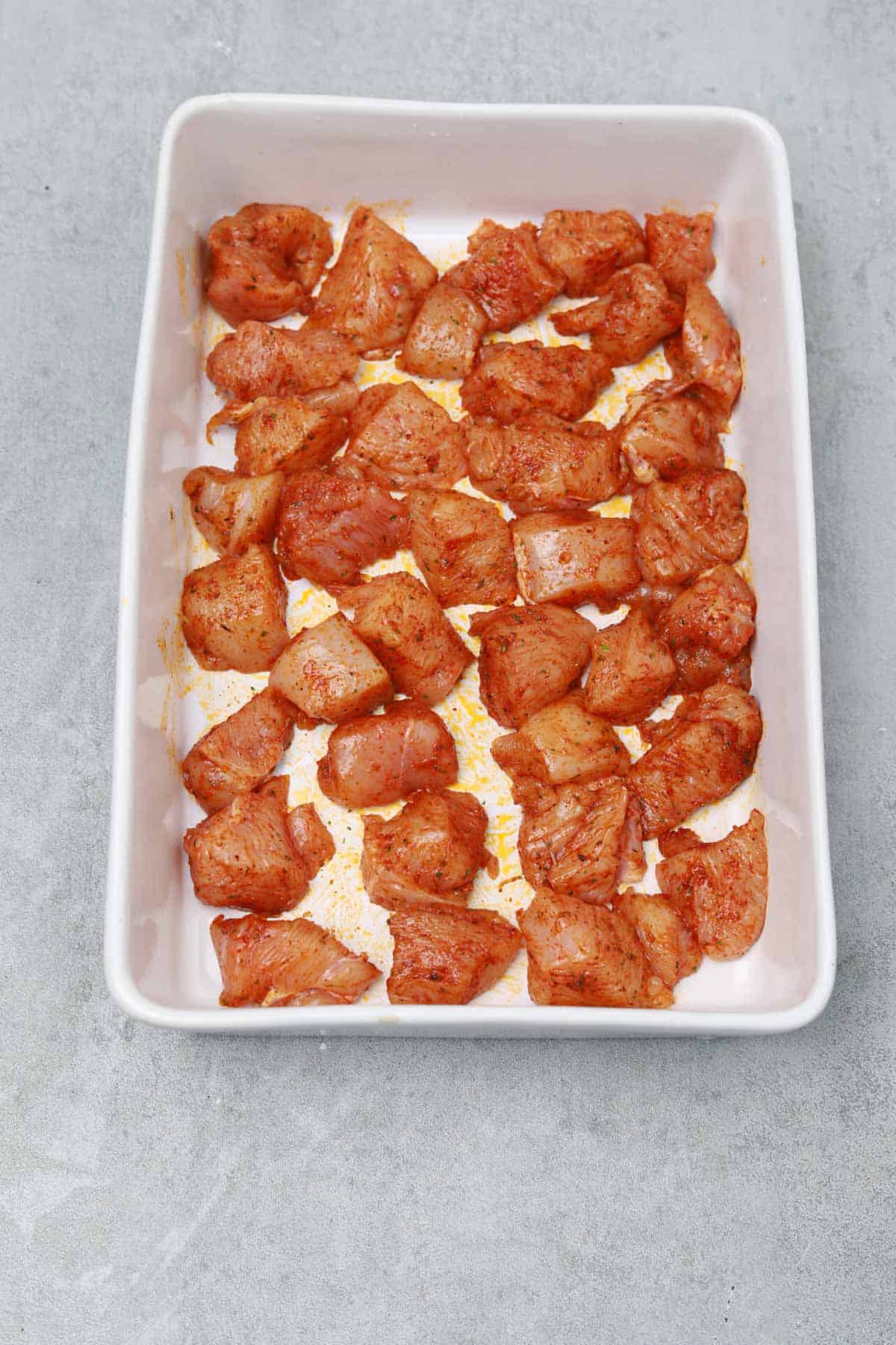 seasoned diced chicken in a baking dish.