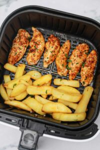 cooked chicken tenders and fries in air fryer.