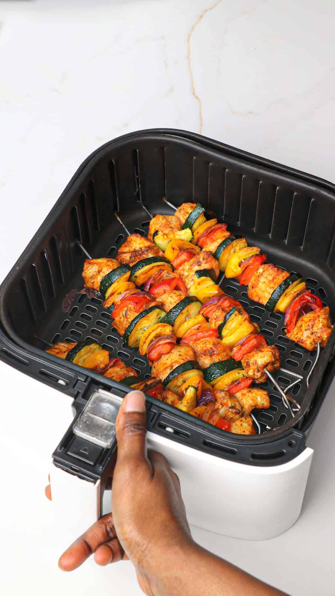 chicken kabobs in air fryer basket.