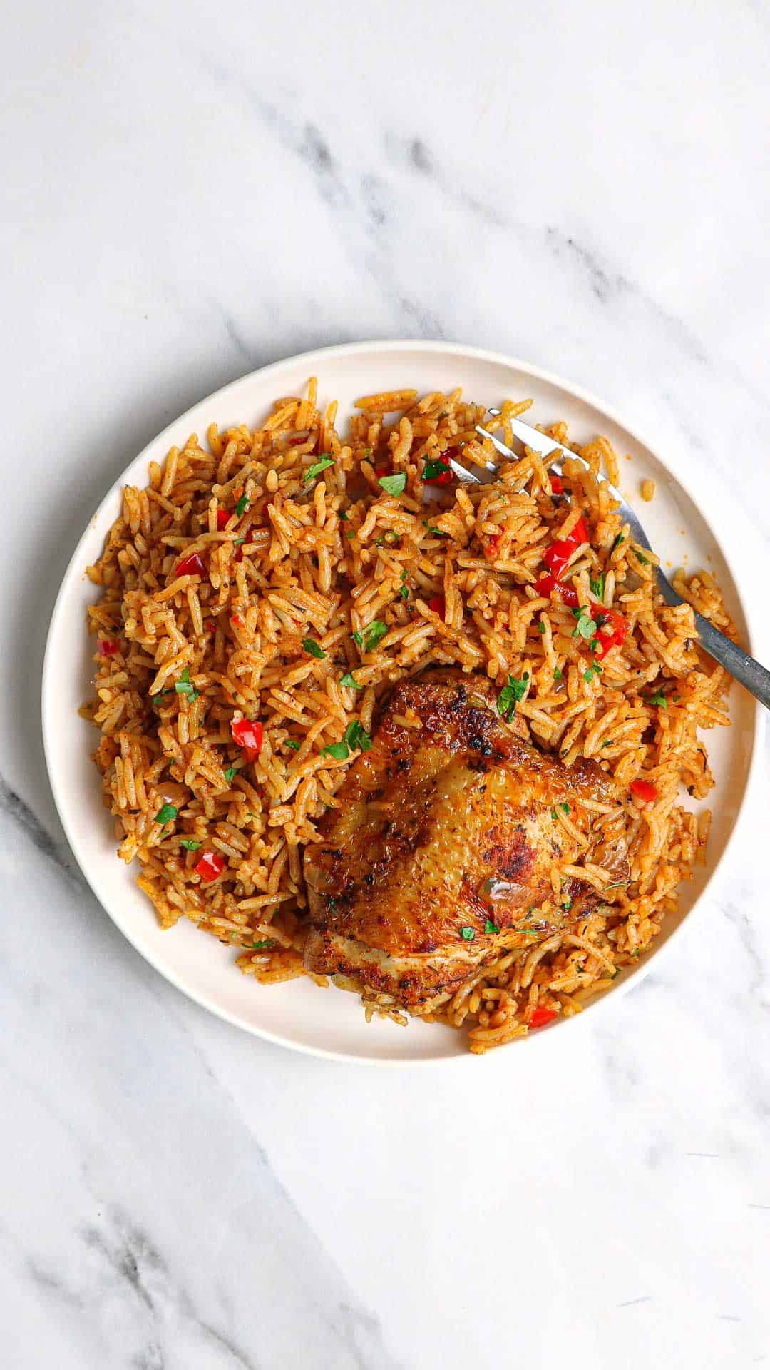 Cajun chicken and rice served on a white plate.