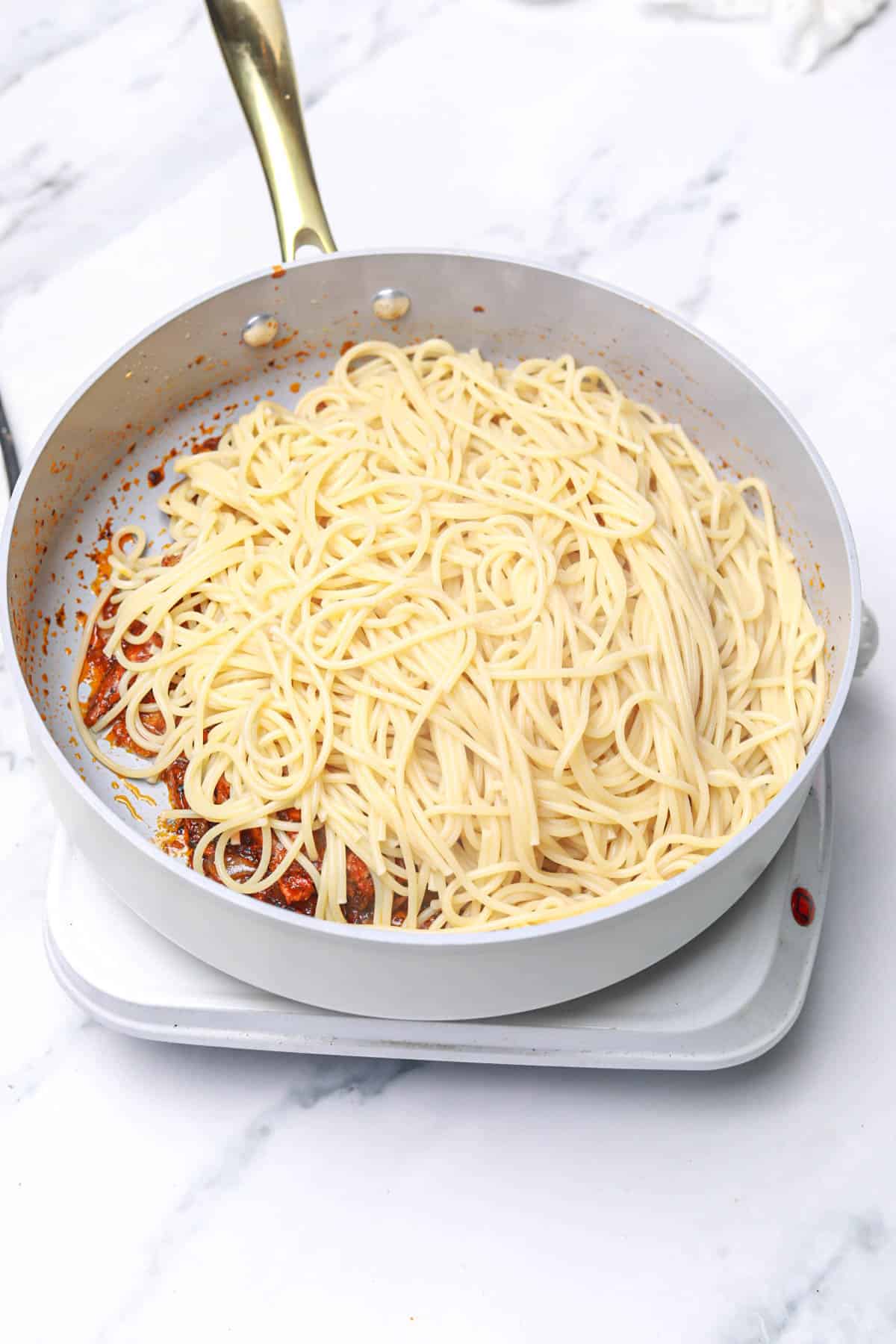 pasta added to the mackerel sauce in the pot.
