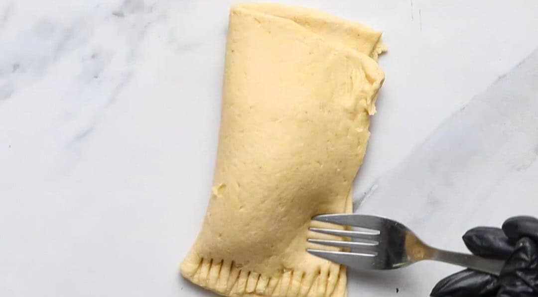 pressing the pastry edges close.