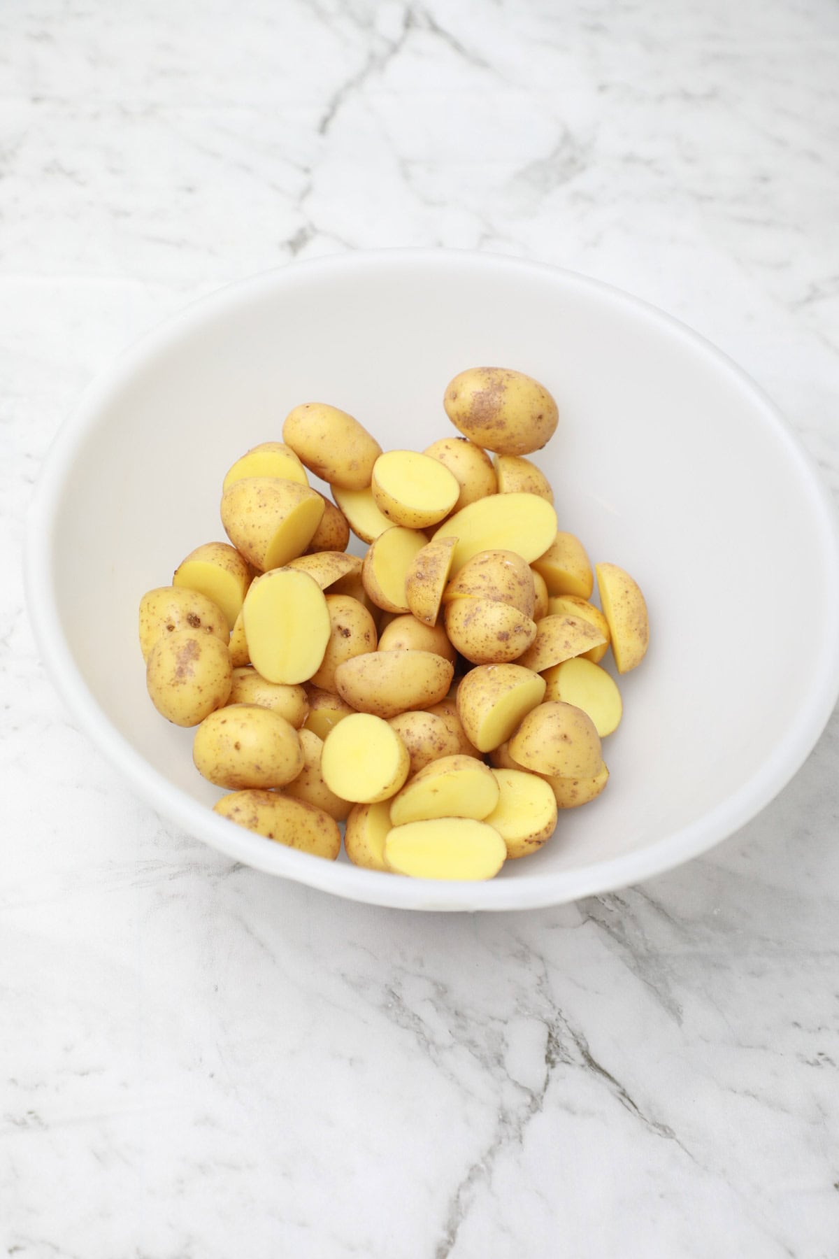 cut baby potatoes in a bowl.