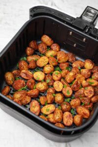 cajun potatoes in air fryer basket.