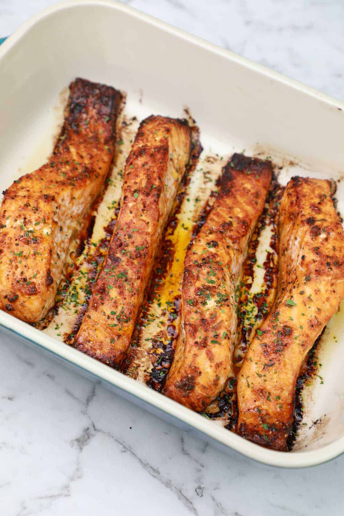 broiled salmon fillets in a baking dish.