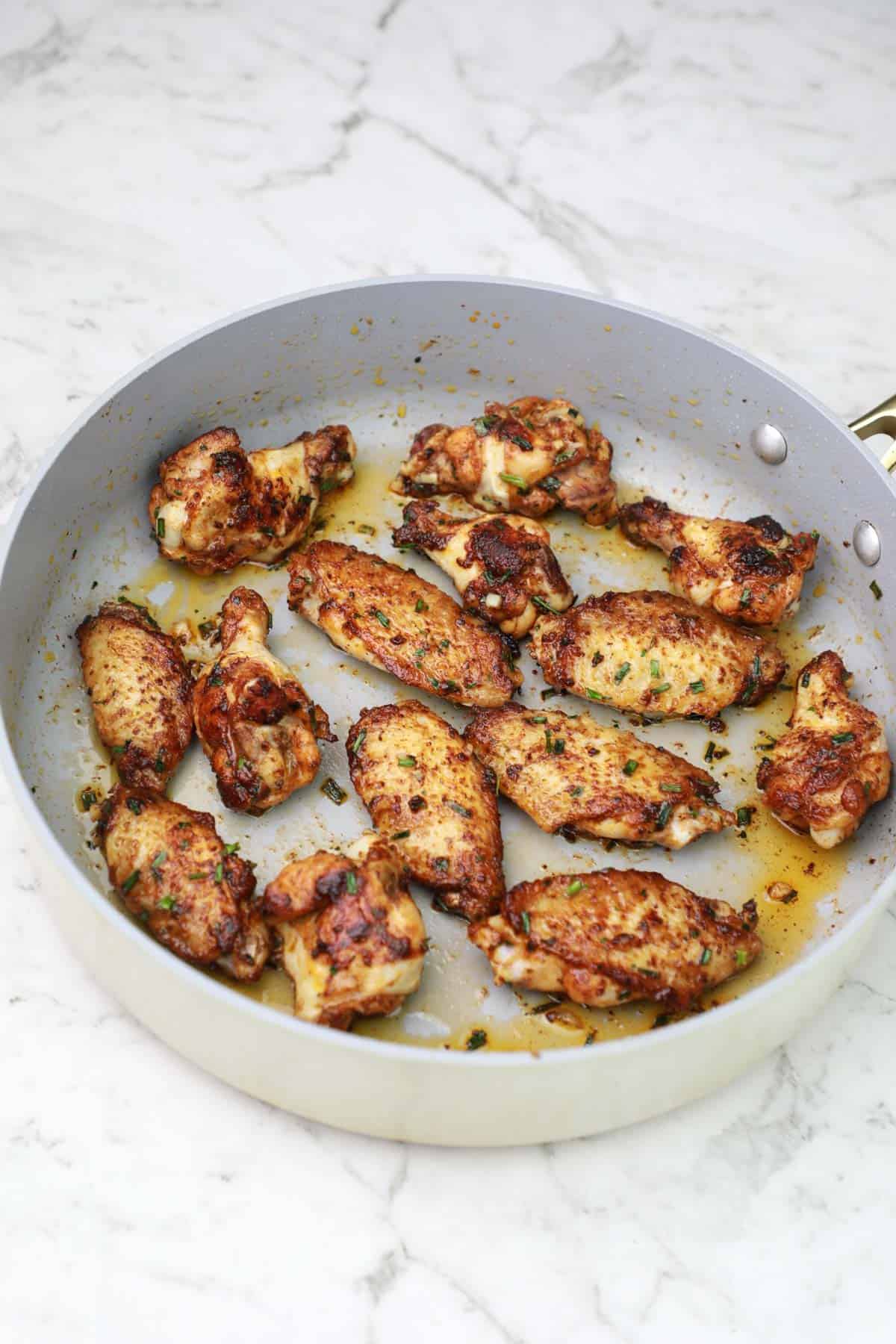 chicken wings fried in a pan.