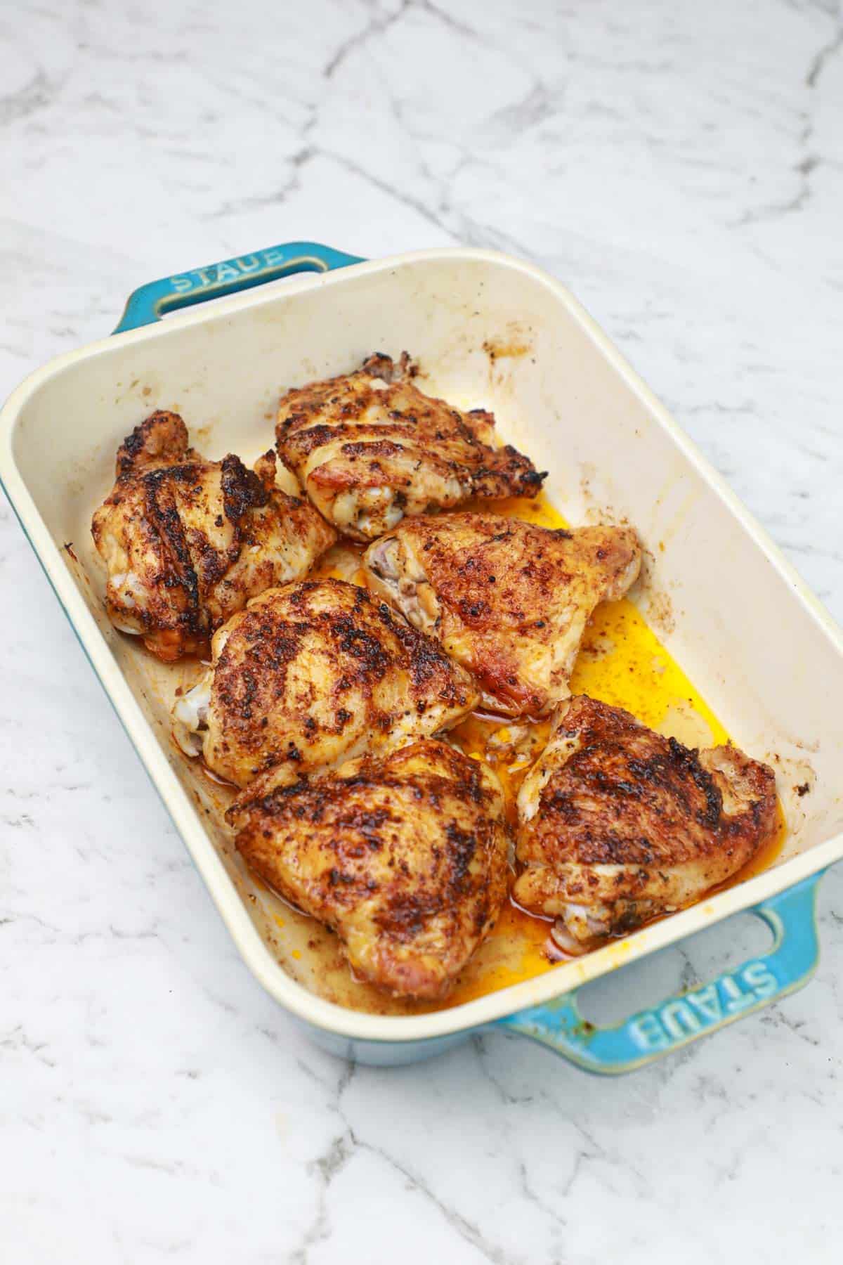 baked frozen chicken thighs in a baking dish.
