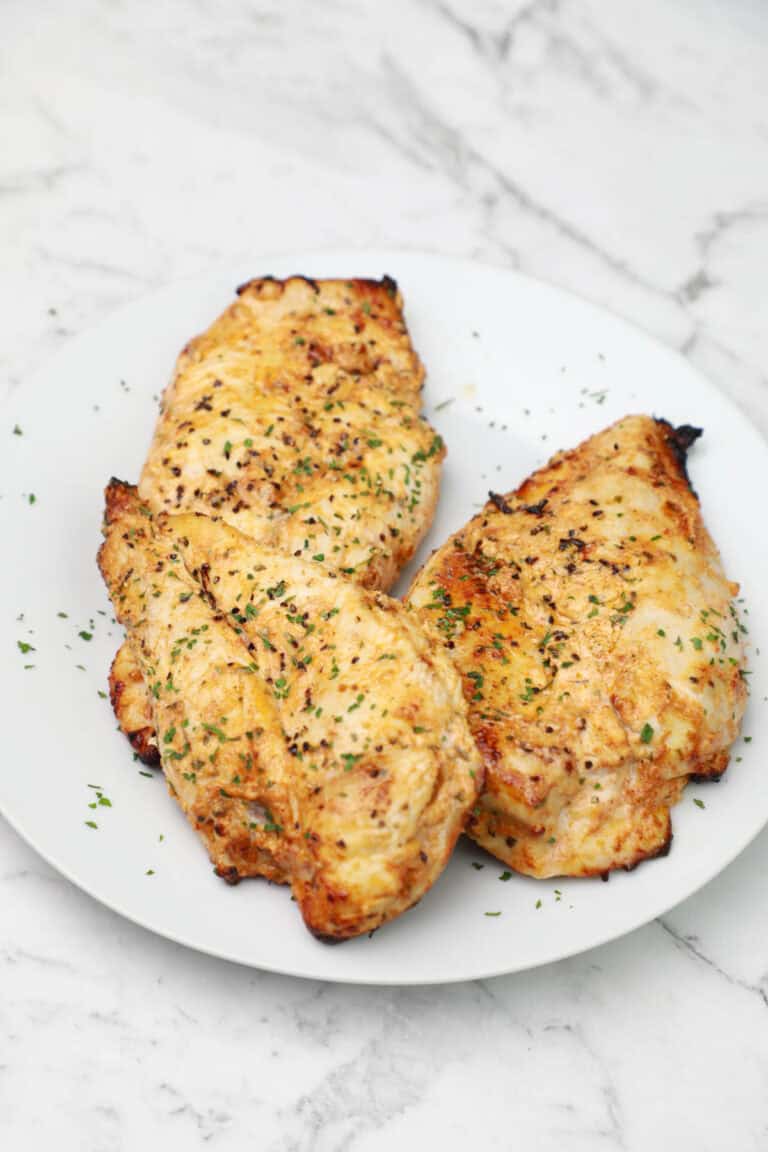 yogurt chicken breast served on a white plate.